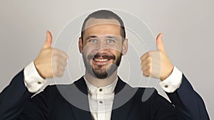 Young handsome businessman is smiling and showing thumb up with two hands.