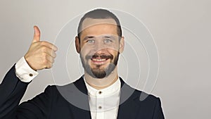 Young handsome businessman is smiling and showing thumb up with two hands.