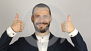 Young handsome businessman is smiling and showing thumb up with two hands.