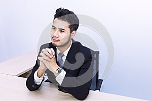 Young handsome businessman smiling and thinking at office .