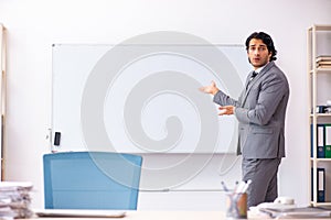 The young handsome businessman standing in front of whiteboard