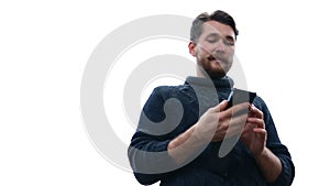 Young and handsome businessman typing sms on an cell phone. White background