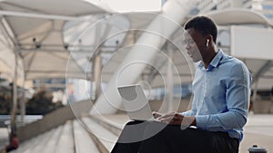 Young Handsome Businessman Using Laptop for Online Meetings, Waving to Clients.