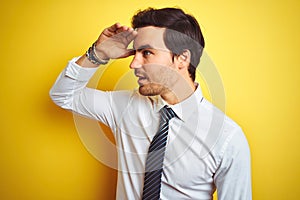 Young handsome businessman wearing elegant shirt and tie over isolated yellow background very happy and smiling looking far away