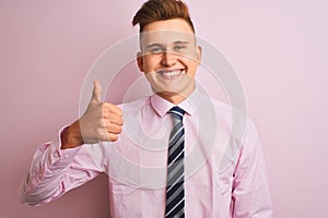 Young handsome businessman wearing shirt and tie standing over isolated pink background doing happy thumbs up gesture with hand