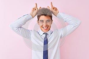 Young handsome businessman wearing shirt and tie standing over isolated pink background Posing funny and crazy with fingers on