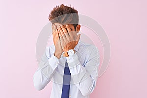 Young handsome businessman wearing shirt and tie standing over isolated pink background with sad expression covering face with