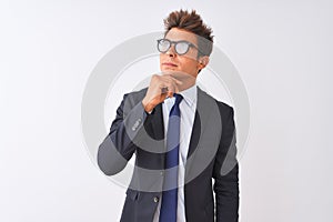 Young handsome businessman wearing suit and glasses over isolated white background with hand on chin thinking about question,