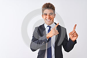 Young handsome businessman wearing suit standing over isolated white background smiling and looking at the camera pointing with