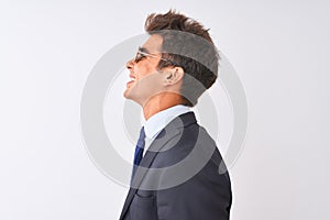 Young handsome businessman wearing suit and sunglasses over isolated white background looking to side, relax profile pose with