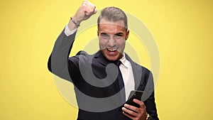 young handsome businessman on yellow background