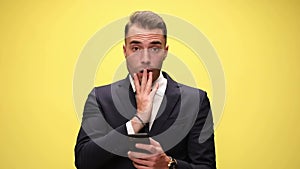 young handsome businessman on yellow background