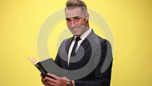 young handsome businessman on yellow background