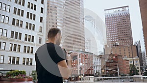 Young handsome businesswoman with documents and smartphone going to work in New York, America. Slow motion.