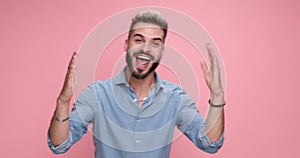 young handsome casual man against pink studio background