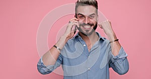 young handsome casual man against pink studio background