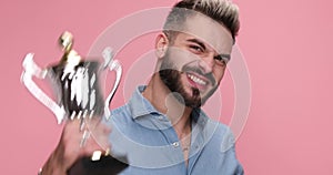 young handsome casual man against pink studio background