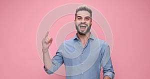 young handsome casual man against pink studio background