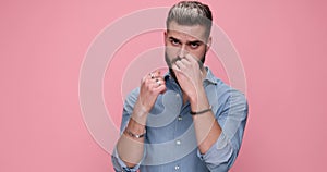 young handsome casual man against pink studio background