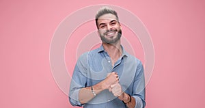 young handsome casual man against pink studio background