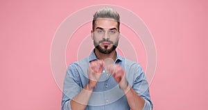 young handsome casual man against pink studio background