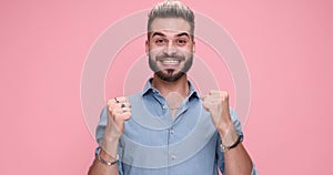 young handsome casual man against pink studio background