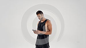 Young handsome caucasian athlete holding smartphone