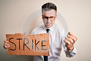 Young handsome caucasian business man holding protest banner on job strike annoyed and frustrated shouting with anger, crazy and