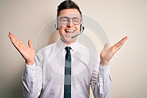 Young handsome caucasian business man wearing call center headset at customer service celebrating mad and crazy for success with