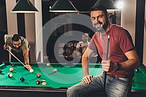 young handsome caucasian man beside billiard table in bar