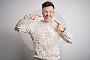 Young handsome caucasian man wearing casual winter sweater over white isolated background smiling cheerful showing and pointing