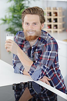 young handsome cheerful man drinking milk