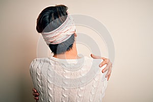 Young handsome chinese man injured for accident wearing bandage and strips on head Hugging oneself happy and positive from
