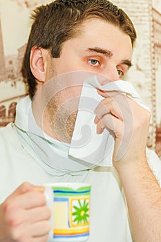 A young handsome cold man covers his mouth photo