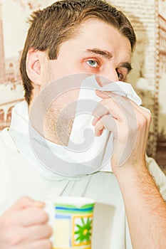 A young handsome cold man covers his mouth photo