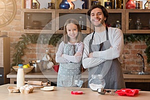 Young Handsome Dad And His Little Daughter In Aprons Posing In Kitchen