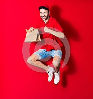 Young handsome deliveryman wearing cap smiling happy