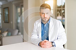 Young handsome doctor man at the clinic skeptic and nervous, frowning upset because of problem