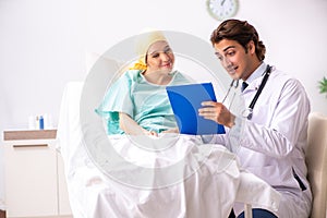 The young handsome doctor visiting female oncology patient