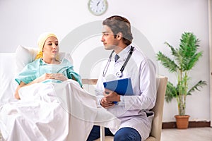 The young handsome doctor visiting female oncology patient