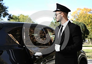 Young handsome driver opening luxury car door photo