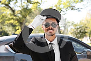 Young handsome driver standing near luxury car