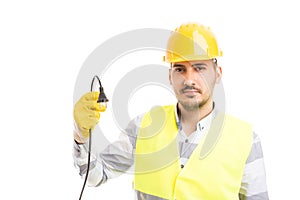 Young handsome electrician holding unplugged cable