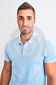 Young handsome elegant man wearing blue t-shirt over isolated background with a confident expression on smart face thinking