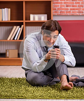 Young handsome employee doing yoga in the office