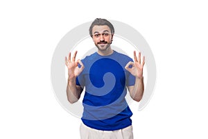 young handsome european man with black hair and beard dressed in a blue t-shirt