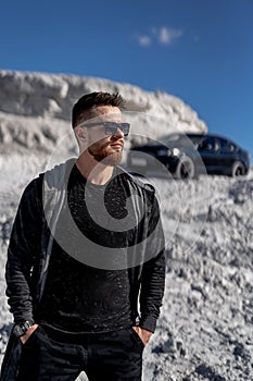 Young handsome fashionable businessman. Stylish model posing with car.