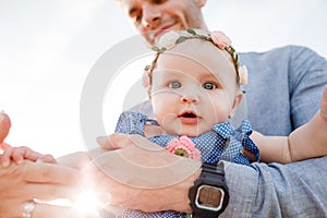 Young handsome father holds little daughter in his hands and smiles on sunny day. Happy family. Father`s day concept. Dad raise u