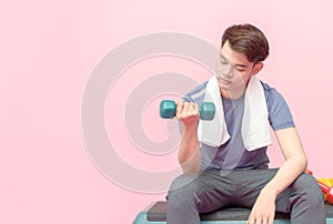 Young handsome fitness man lifting dumbbell