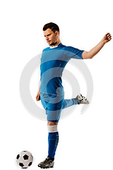 Young handsome football player holds kicking soccer ball posing on white isolated background.